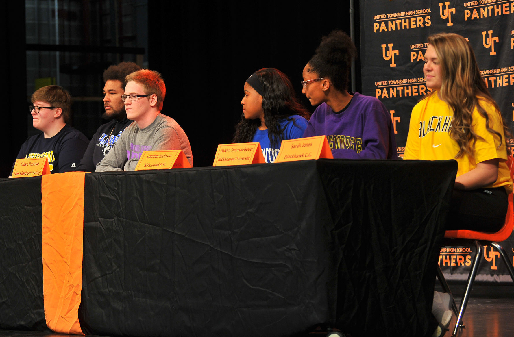 United Township athletes signing letters of accepting scholarship to colleges.